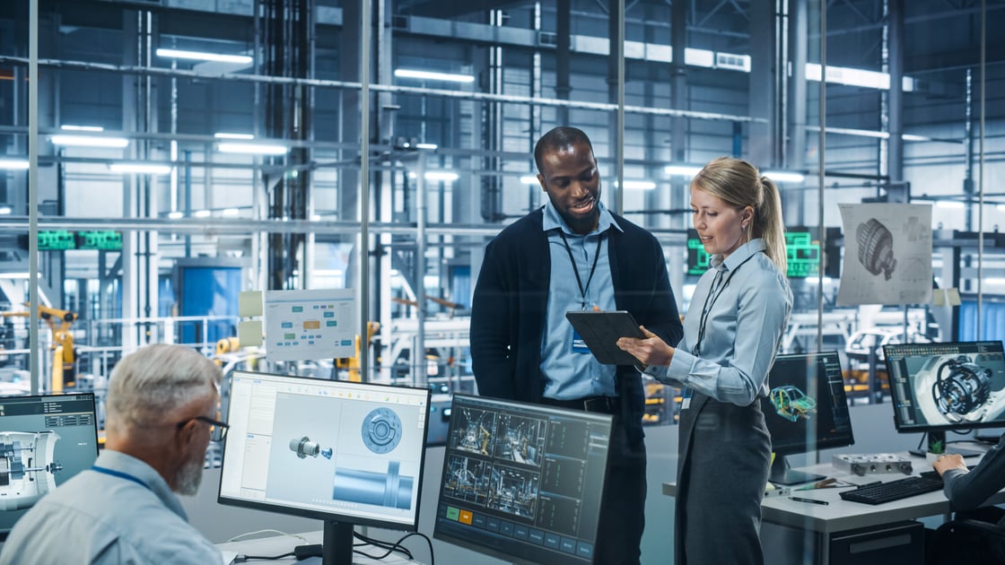 People working in manufacturing lab, talking to each other holding ipad